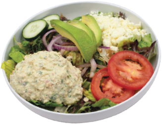 A white bowl filled with leafy greens, tomato slices, avocado, sliced cucumber, red onion, crumbled cheese, and a scoop of tuna or chicken salad.